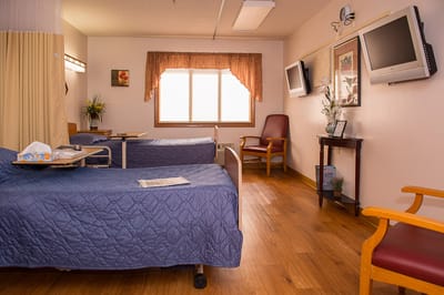 Private resident room with two beds and seating area