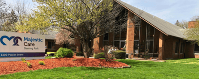 Majestic Care of Bedford, Nursing Home in Bedford, IN — Senior living facility with landscaped gardens and signage