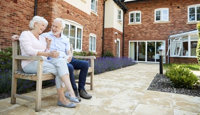 Senior couple enjoying time outdoors at their facility.