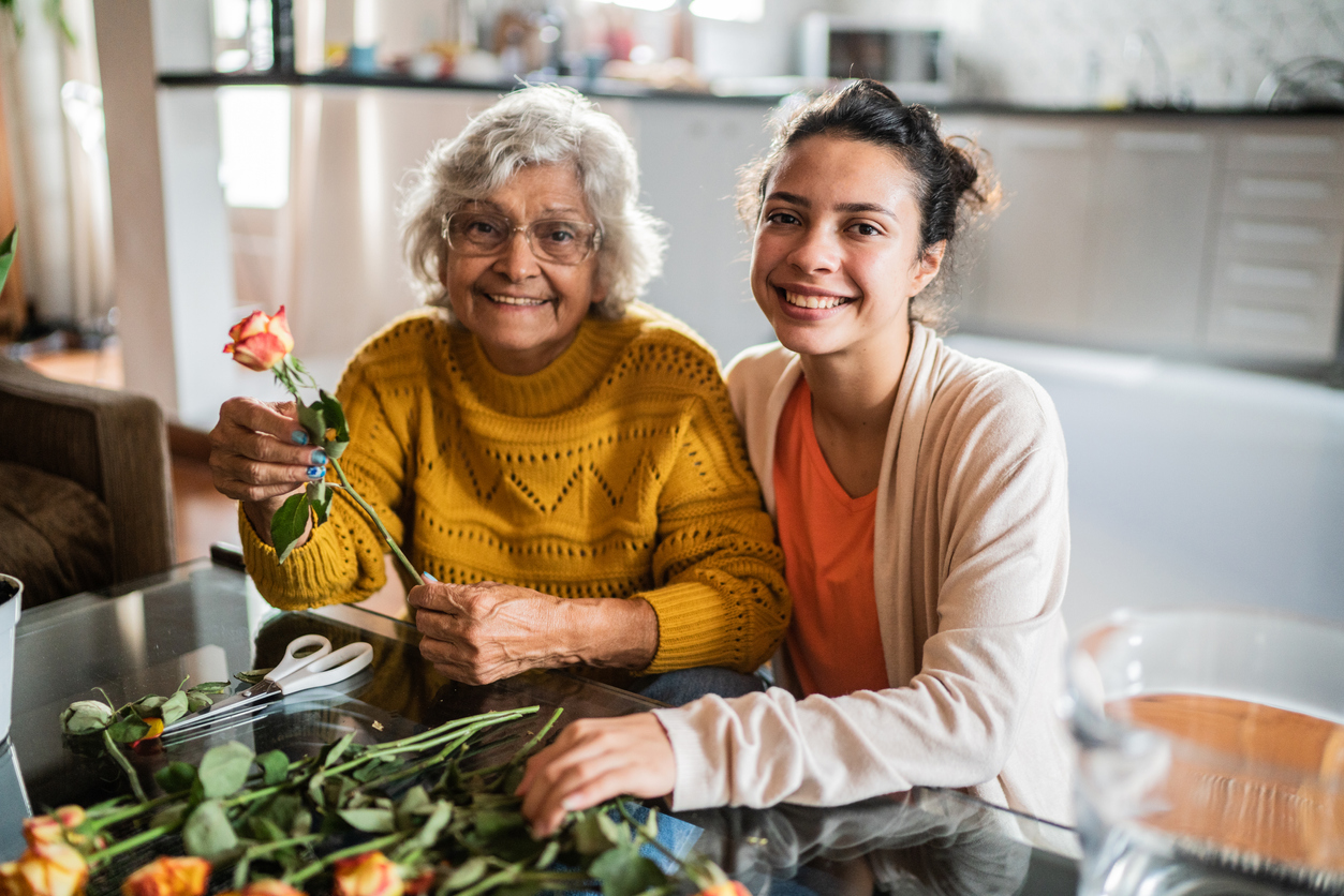 Senior resident and caregiver enjoying flower arranging