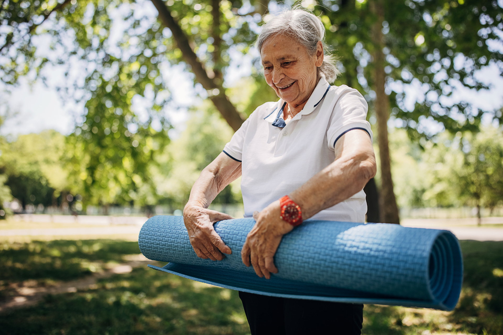 Senior woman preparing for yoga in a park