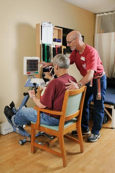 Staff assisting a resident with therapy exercise