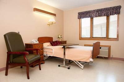 Private resident room with a bed and chair
