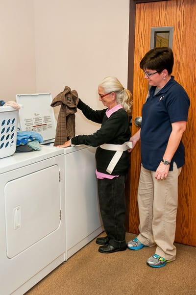 Staff assisting a resident with laundry