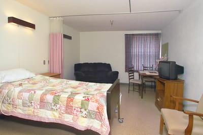 Private resident room with a bed and seating area