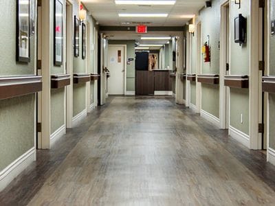 Bright hallway with framed pictures in a senior living facility