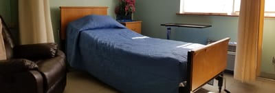 Private resident room with a bed and chair