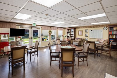 Common area with tables and seating in a senior living facility