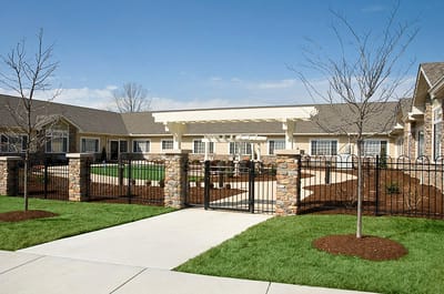 Exterior view of a senior living facility with gardens