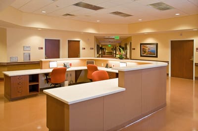 Reception area with orange chairs and a counter