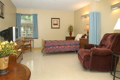 Cozy resident room with a bed and armchair