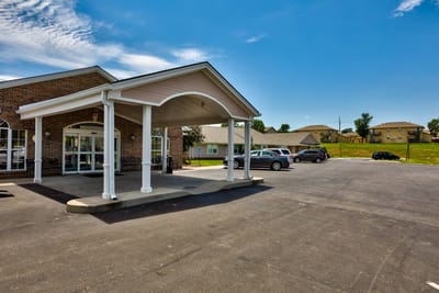 Entrance area of a nursing home facility with vehicles parked