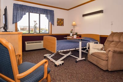 Private resident room with hospital bed and cozy seating