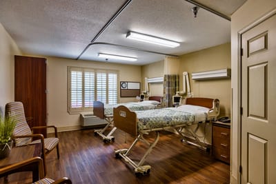 Private resident room with two beds and a window