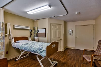 Private resident room with hospital bed and amenities