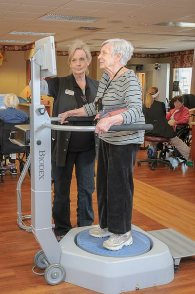 Staff assisting a resident with therapy equipment