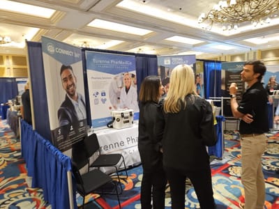 Visitors at a pharmacy services booth in an expo setting