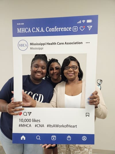 Three women smiling at a conference