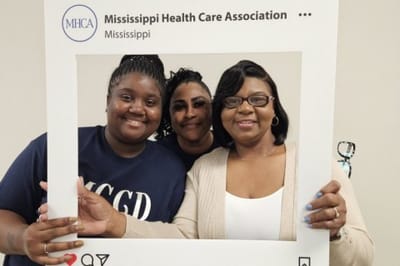 Three women smiling in a common area