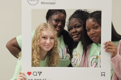 Four staff members posing together with a photo frame