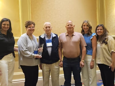 Group photo of staff and award recipient at event