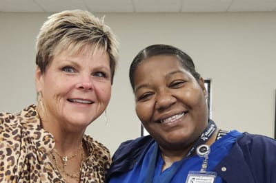 Two staff members smiling in a facility setting