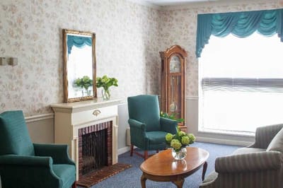 Cozy sitting area with teal chairs and a fireplace