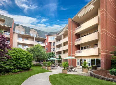Exterior view of a senior living facility with gardens