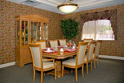 Dining area with a large wooden table and floral wallpaper