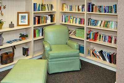 Cozy reading nook with bookshelves and green chair