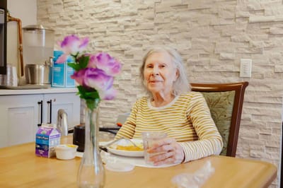 A resident enjoying a meal in a cozy dining area