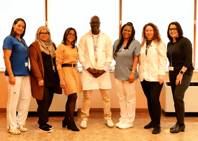 Staff members posing together in a bright hallway