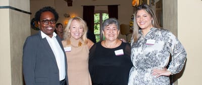 Four smiling staff members in a common area