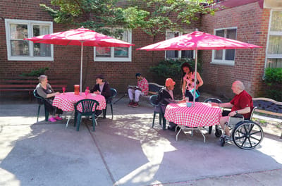 Residents enjoying time outdoors under umbrellas