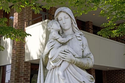 Statue of Mary and child in front of a building