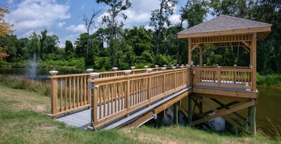 Wooden gazebo overlooking a serene pond with greenery
