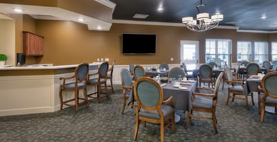 Interior dining area with tables and chairs set for meals