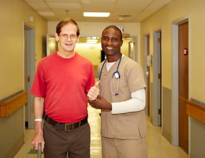 Staff member assisting a resident in a hallway