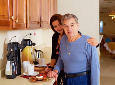 A resident and staff member at a coffee station