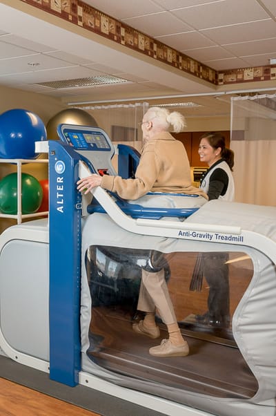 Resident using an anti-gravity treadmill during therapy