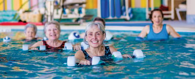 Residents enjoying a water aerobics class in a pool