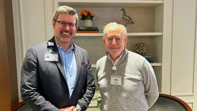 Staff member and resident posing in a welcoming common area