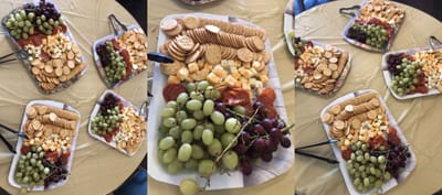 A spread of snacks, fruits, and cheeses on a table