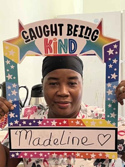 Resident holding a 'Caught Being Kind' sign