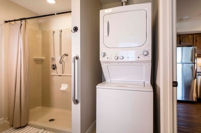 Laundry area with stacked washer and shower