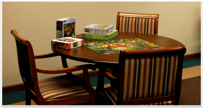 Puzzle pieces and boxes on a table in a common area