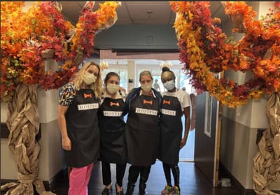 Staff members posing in an autumn-decorated lobby