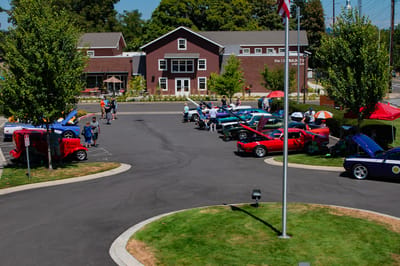 Community event with classic cars and residents interacting