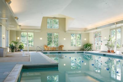 Indoor pool area with large windows and seating