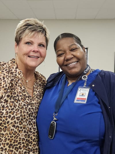 Two staff members smiling together in a facility
